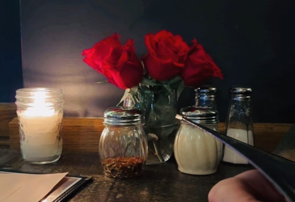 love letter, red roses, candle lit restaurant